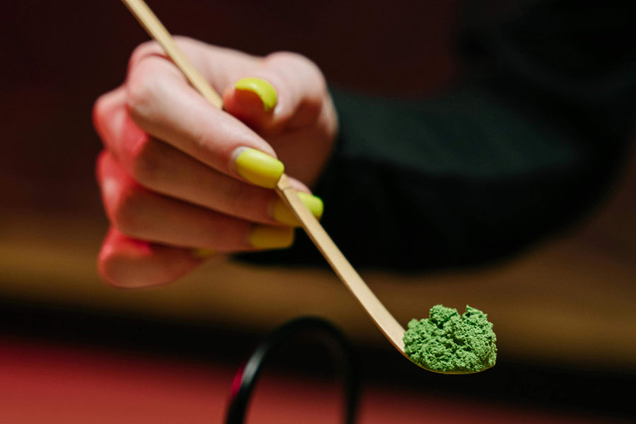 a teaspoonful of green kratom powder|a researcher holding a green-leafed plant