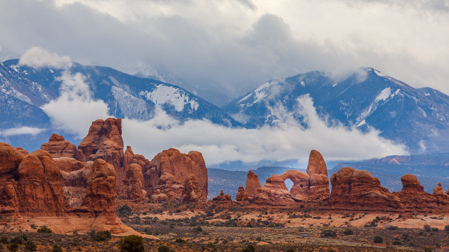 Towering red rocks against a mountain landscape in Moab, Utah|