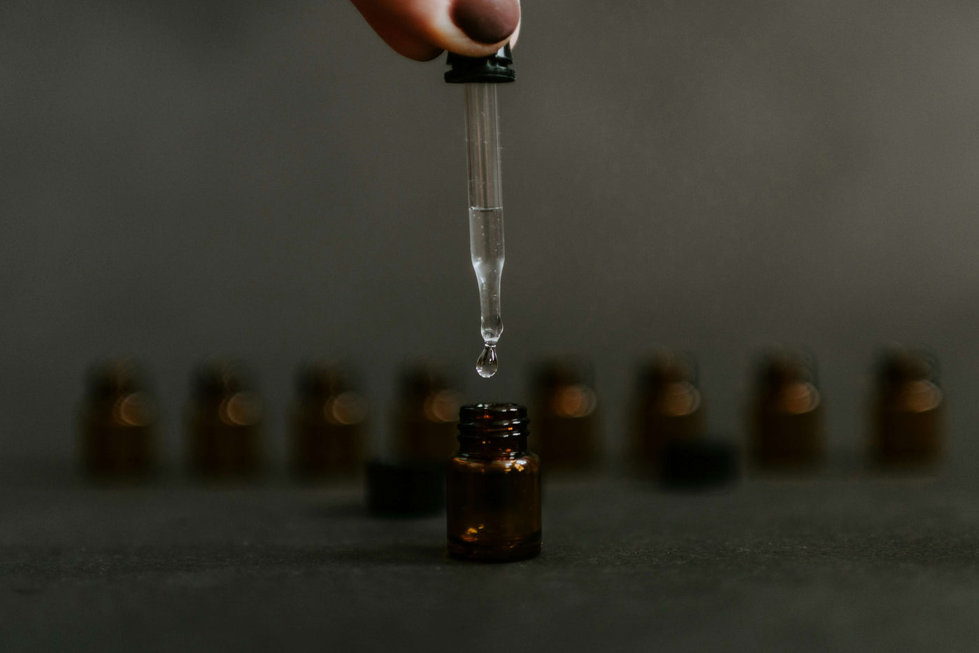 Person dropping liquid in dropper|