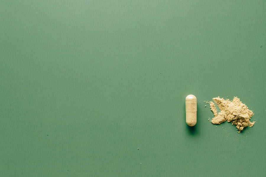 kratom capsule on green background|person putting a leaf on a microscope